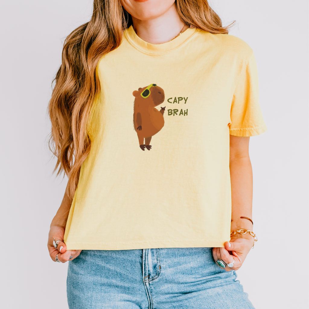 A yellow boxy fit t-shirt featuring a graphic of a capybara with the text 'CAPY BRAH' on the front.