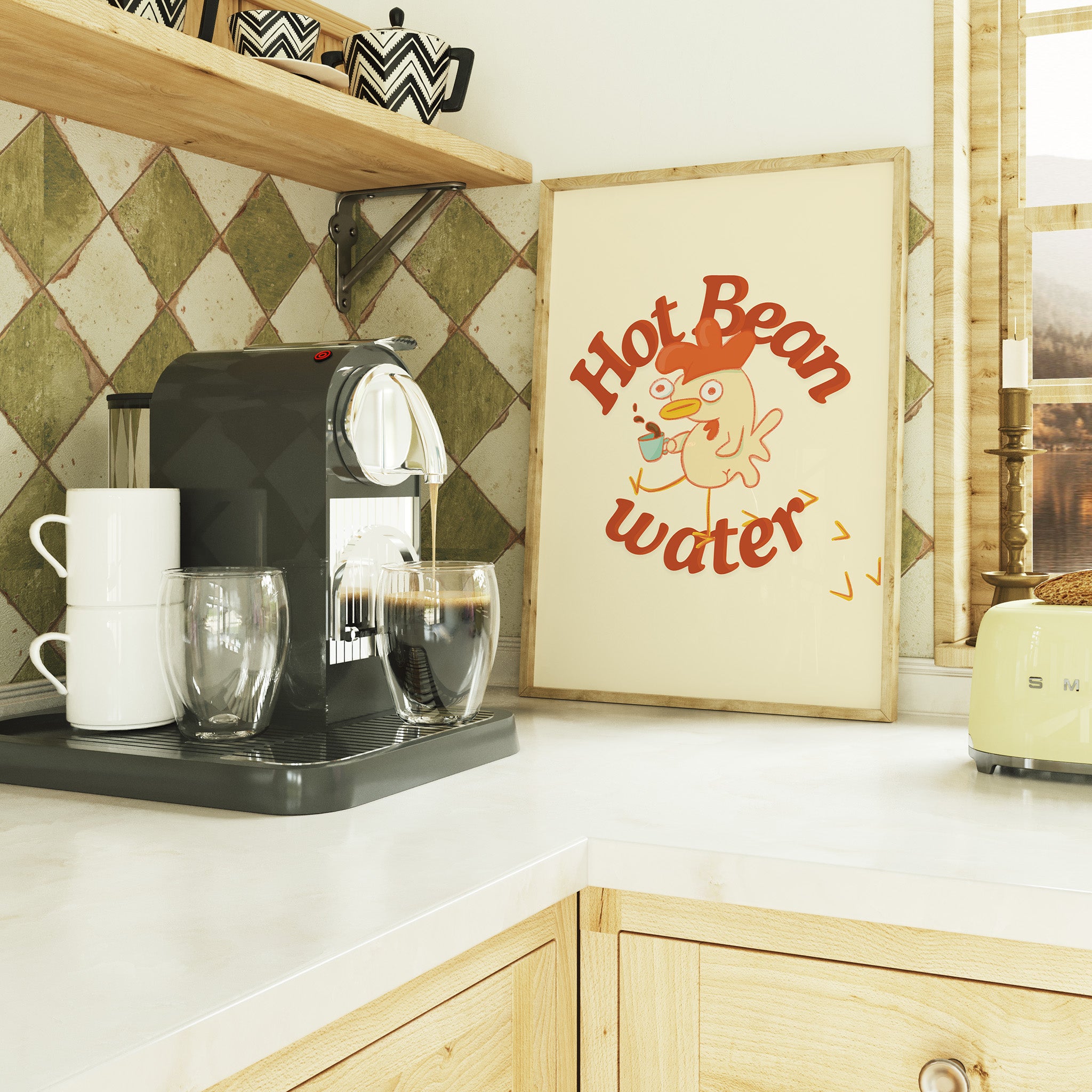 a funny coffee art print that features a chicken holding a cup of coffee next to text that reads "hot bean water" is framed and sitting on a trendy kitchen countertop next to an espresso machine