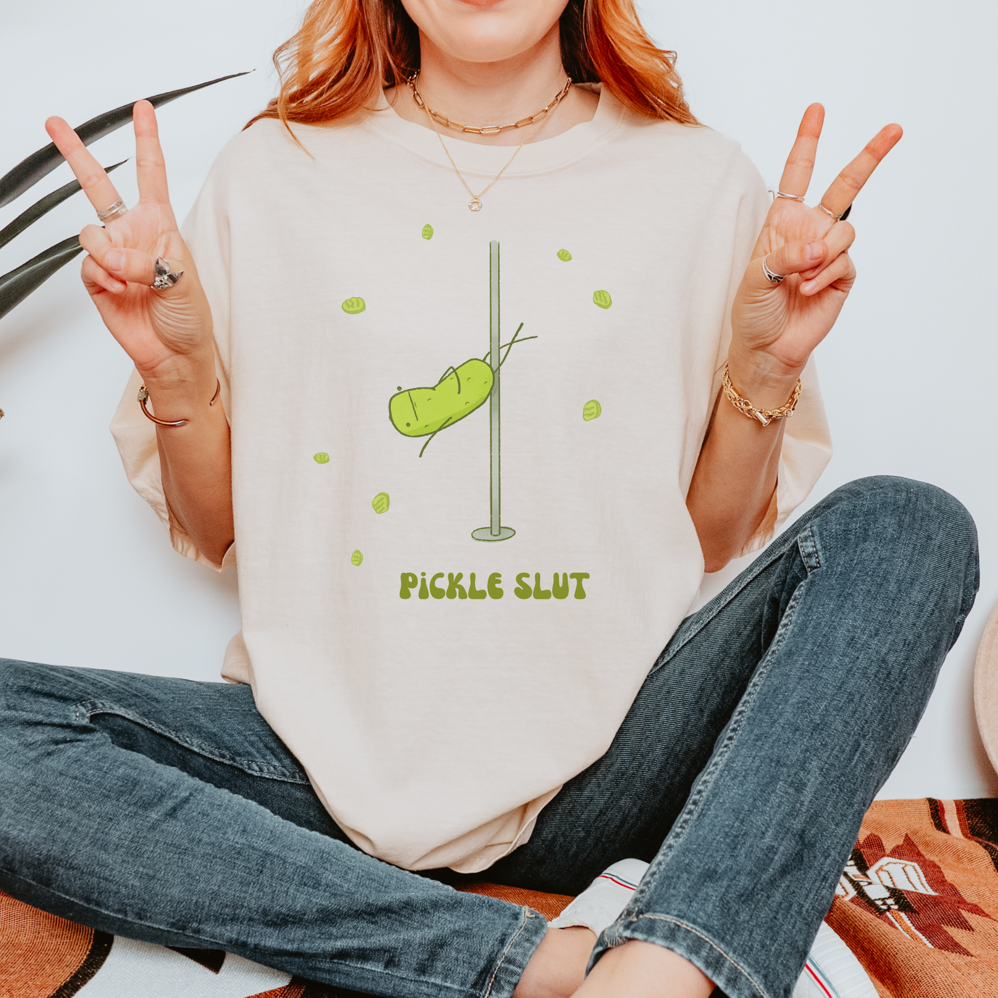 Relaxed fit unisex t-shirt with a funny illustration of a pole-dancing pickle and bold text that says 'Pickle Slut'
