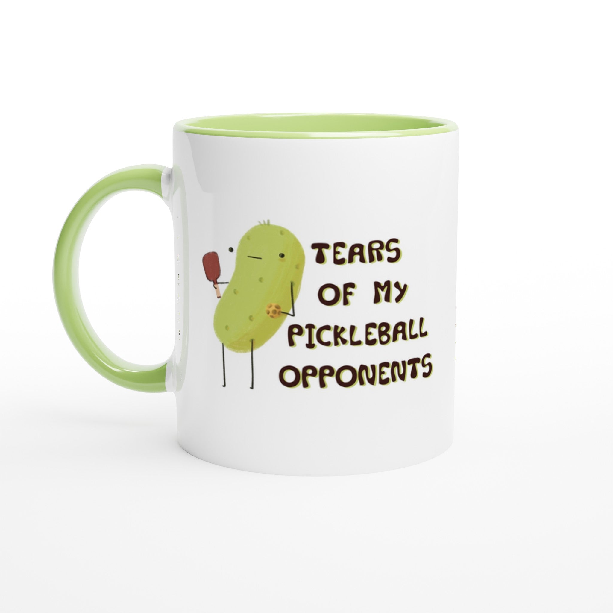 front right view of a pickleball mug with funny quote that says "tears of my pickleball opponents" next to illustration of a pickle holding a pickleball and paddle