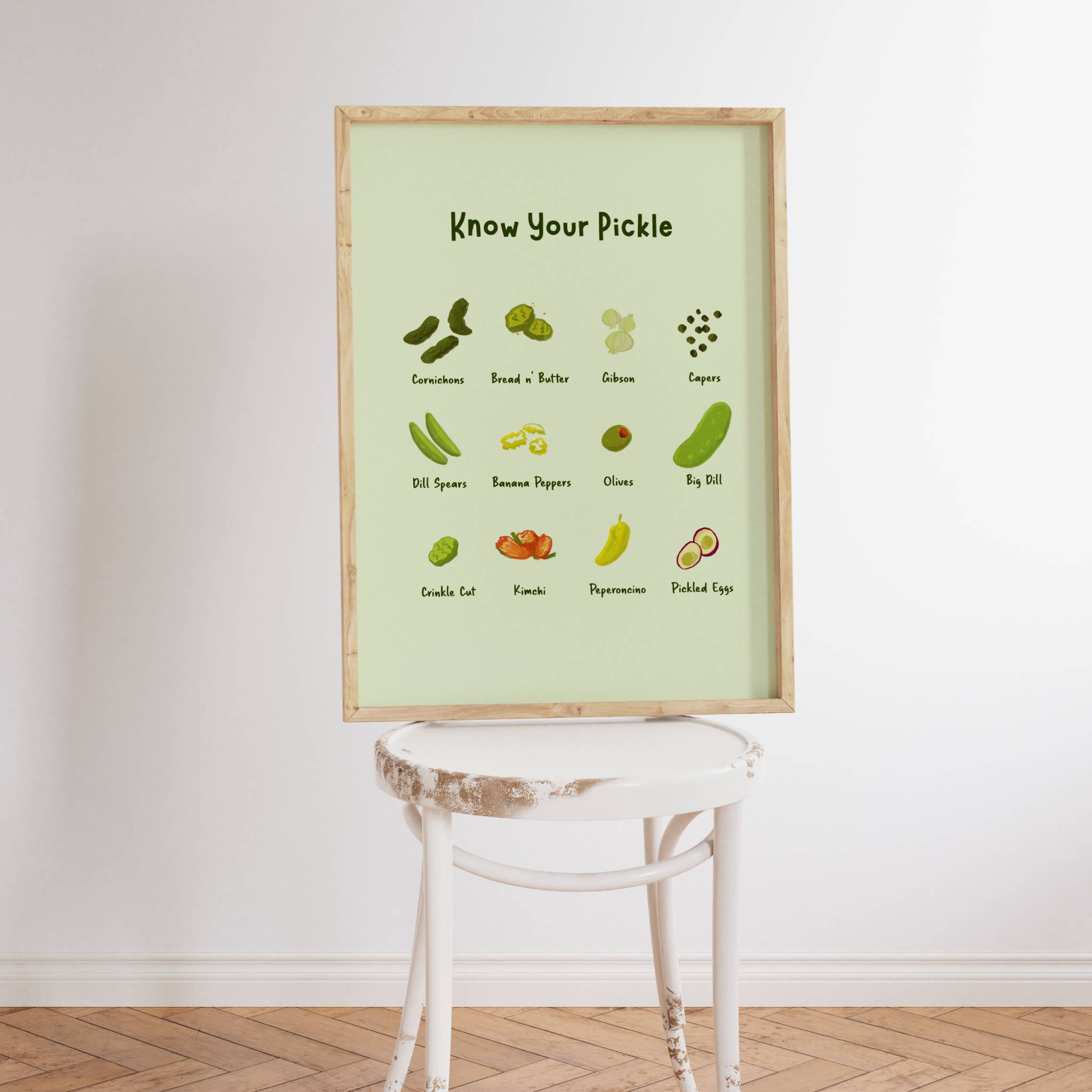 Pickle Art is displayed in a cute wooden frame and rested on a kitchen chair